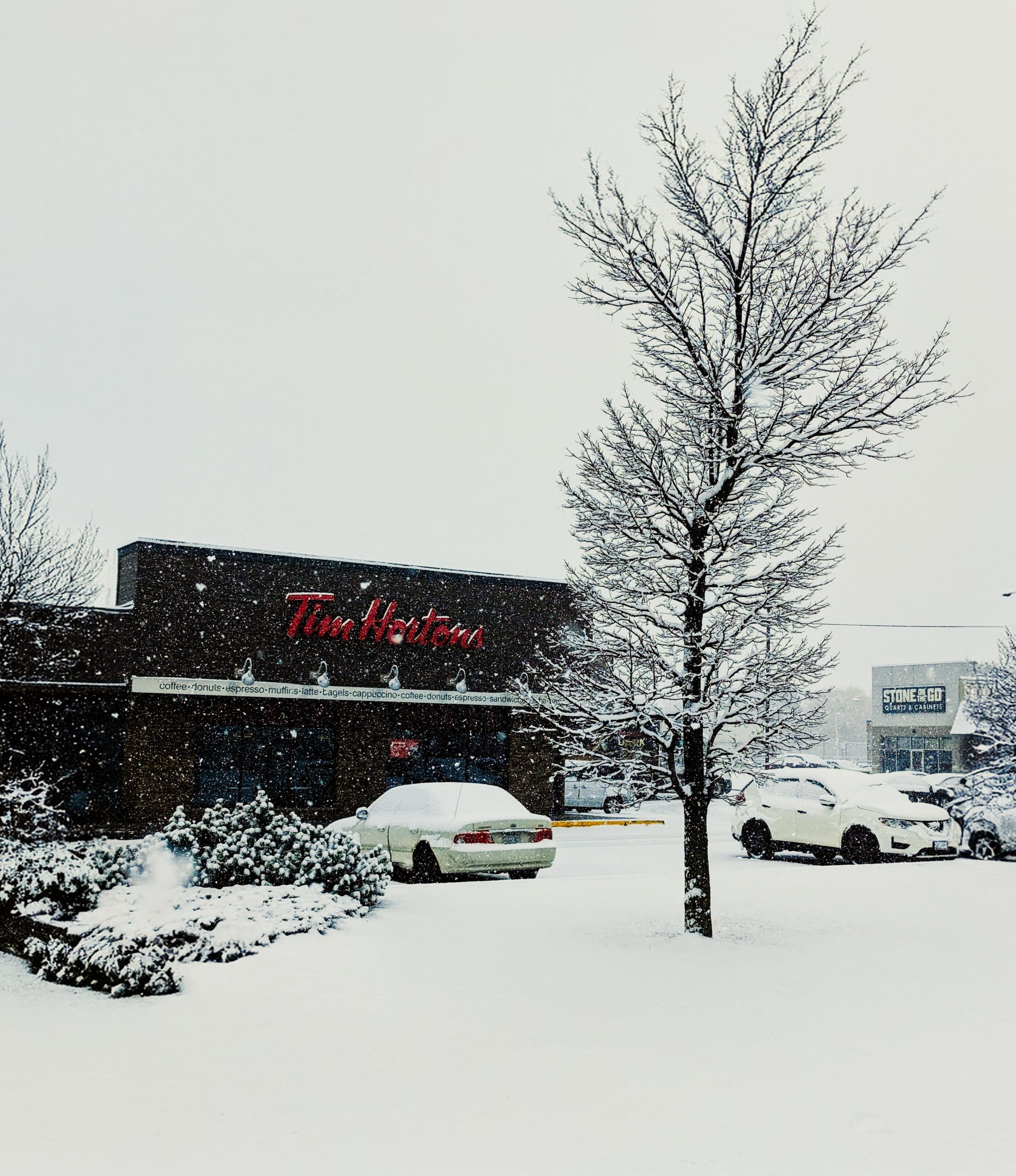 Tim Hortons restaurant surrounded by snow during a winter day, showcasing a seasonal Canadian scene.